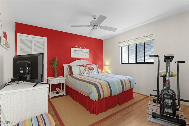 bedroom with ceiling fan, baseboards, and wood finished floors