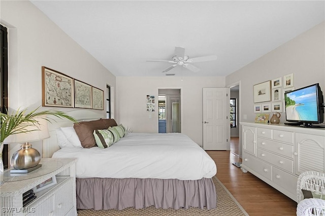 bedroom with dark wood-style floors and a ceiling fan