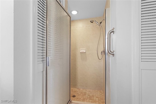 bathroom featuring a stall shower and a closet