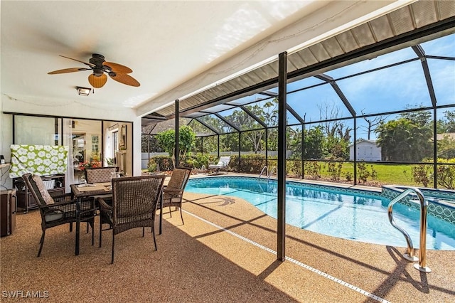 pool with glass enclosure, a patio, and a ceiling fan