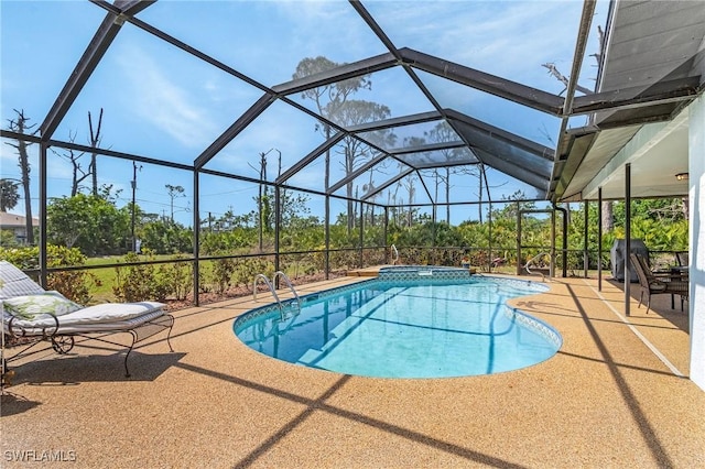 view of pool featuring glass enclosure, a patio, and a pool with connected hot tub