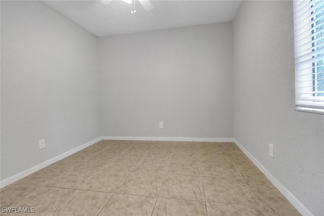 empty room with baseboards and a ceiling fan