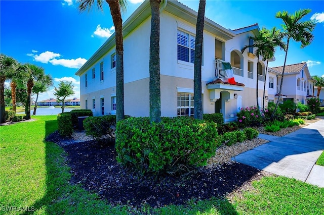 view of property exterior with a residential view, stucco siding, and a lawn