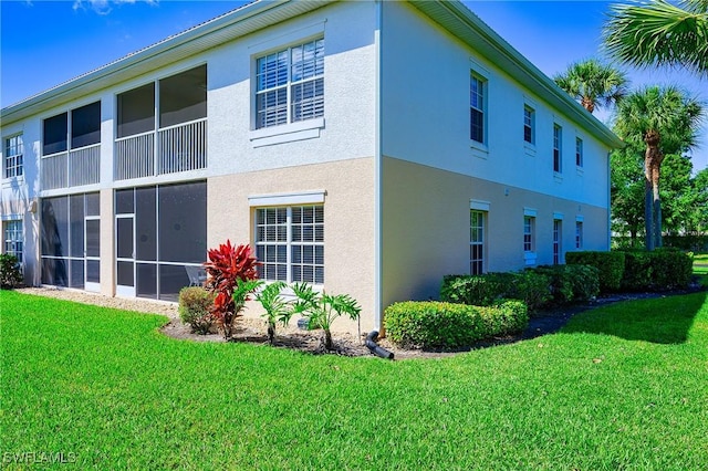 view of property exterior with stucco siding and a yard