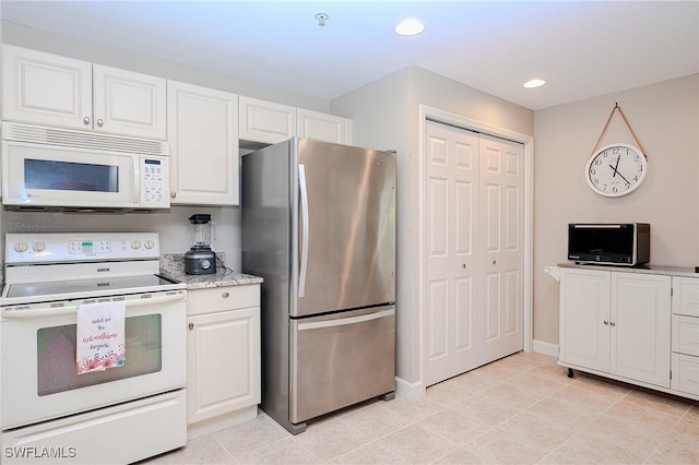 kitchen with white cabinetry, recessed lighting, white appliances, light tile patterned floors, and baseboards