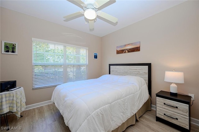 bedroom with ceiling fan, baseboards, and wood finished floors