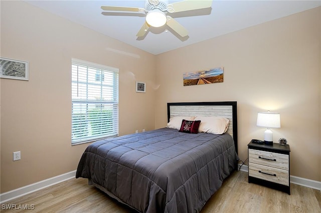 bedroom with visible vents, baseboards, and wood finished floors