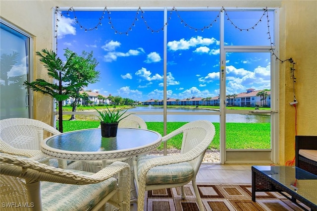 sunroom / solarium featuring a water view