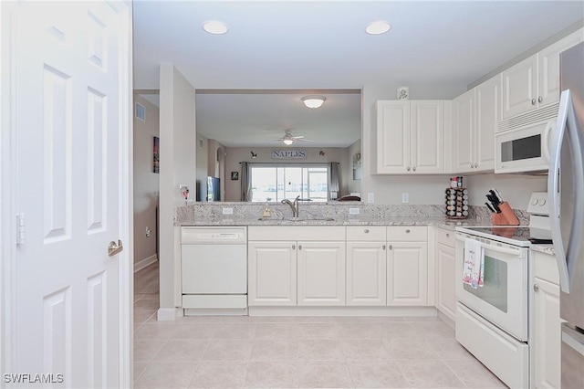 kitchen with white appliances, light stone countertops, ceiling fan, a sink, and white cabinets