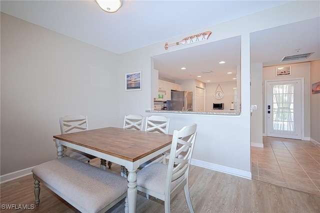 dining area featuring recessed lighting, baseboards, and light wood-type flooring