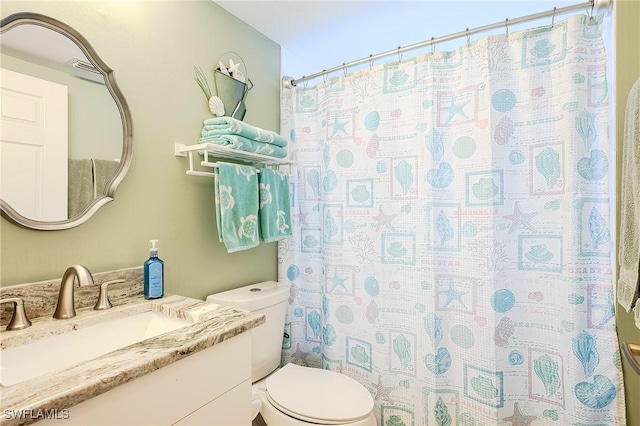 full bathroom with curtained shower, toilet, and vanity