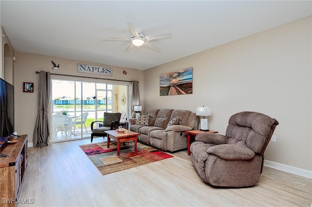 living room featuring baseboards, ceiling fan, and wood finished floors