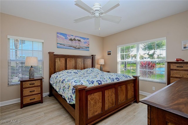 bedroom featuring light wood finished floors, a ceiling fan, and baseboards