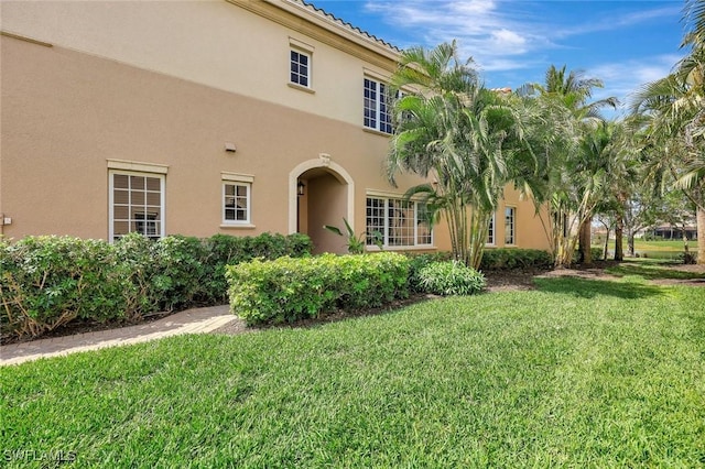 9293 Menaggio Ct Unit 102, Naples, FL 34114 - view of side of property featuring stucco siding and a lawn