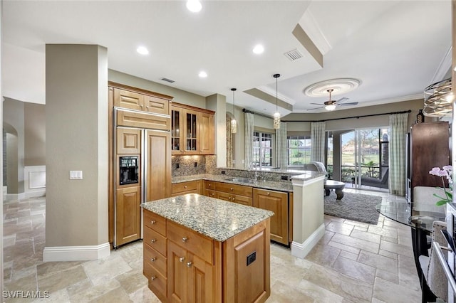 9293 Menaggio Ct Unit 102, Naples, FL 34114 - kitchen with a ceiling fan, paneled refrigerator, a peninsula, a sink, and stone tile flooring
