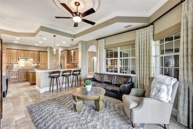 9293 Menaggio Ct Unit 102, Naples, FL 34114 - living room with visible vents, a tray ceiling, arched walkways, stone tile flooring, and ceiling fan