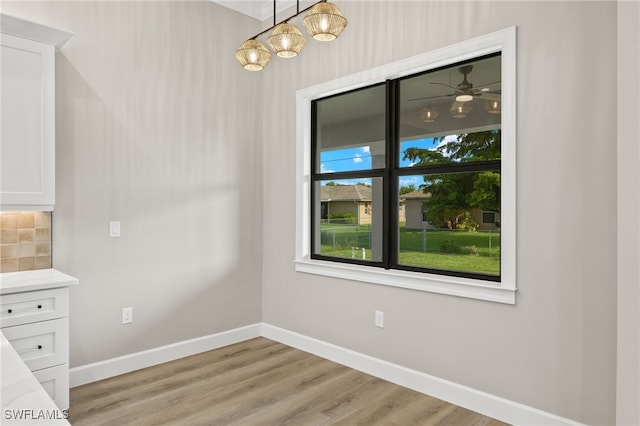 unfurnished dining area with baseboards and light wood-style floors