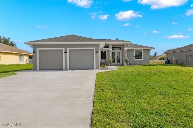 prairie-style home with french doors, driveway, a front yard, and stucco siding