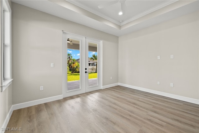 spare room with ornamental molding, wood finished floors, baseboards, and ceiling fan