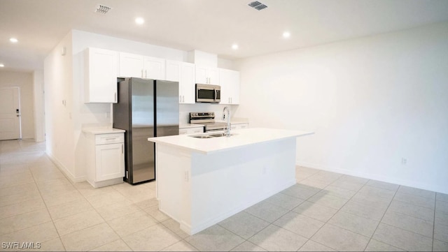 kitchen featuring visible vents, a center island with sink, appliances with stainless steel finishes, white cabinets, and a sink