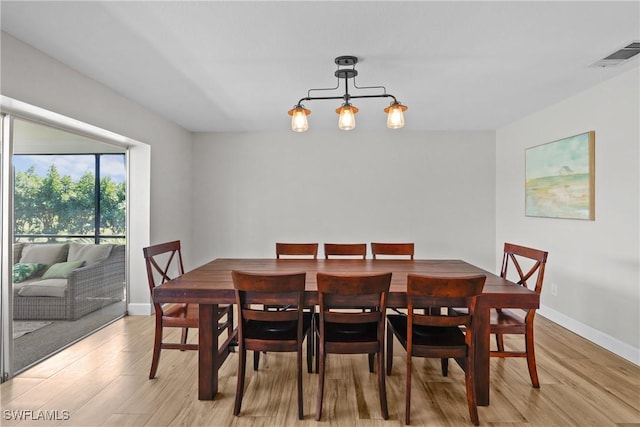 dining area with visible vents, baseboards, and light wood-style floors