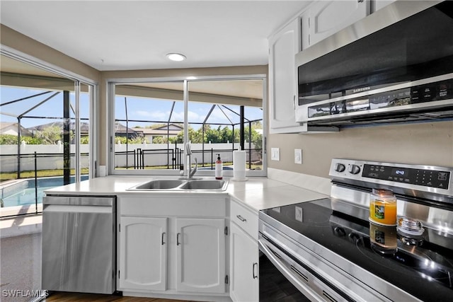 kitchen featuring a sink, plenty of natural light, white cabinetry, and stainless steel appliances