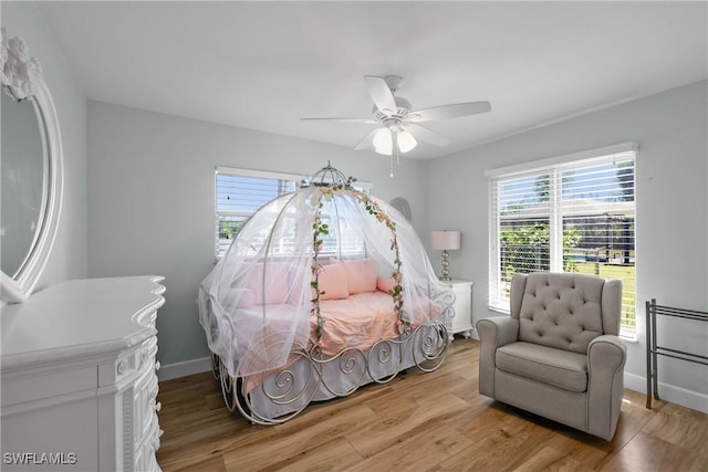 bedroom featuring baseboards, light wood-style floors, and a ceiling fan