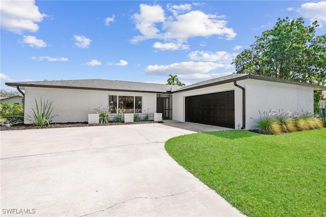 view of front of property with stucco siding, a front lawn, concrete driveway, an attached garage, and brick siding