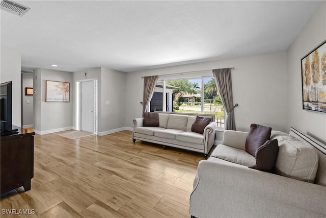 living area with visible vents, baseboards, and light wood-style floors