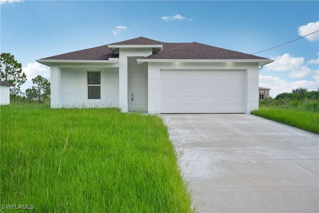 prairie-style home with stucco siding, concrete driveway, a garage, and roof with shingles