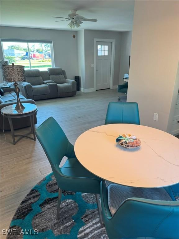 dining room with baseboards, light wood-style floors, and ceiling fan