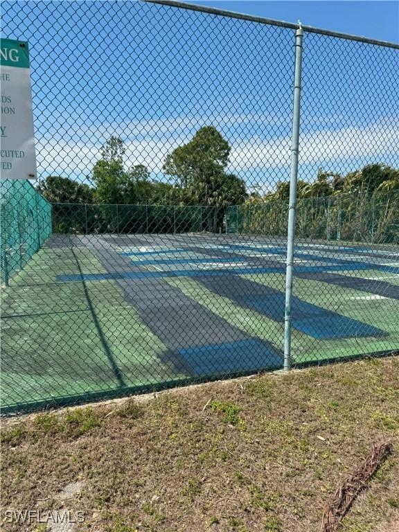 view of tennis court featuring fence