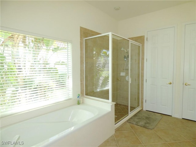 full bath featuring tile patterned floors, a bath, and a shower stall