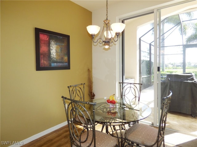 dining space featuring a notable chandelier, wood finished floors, baseboards, and a wealth of natural light