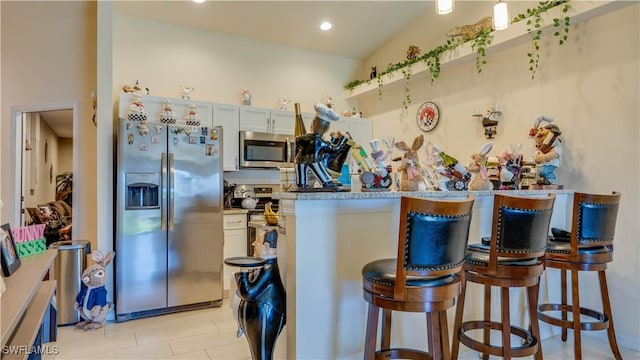 kitchen featuring a kitchen bar and appliances with stainless steel finishes