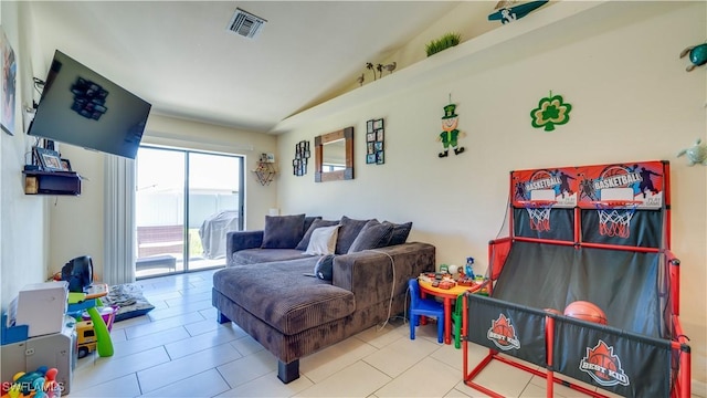 living room with lofted ceiling, visible vents, and tile patterned floors