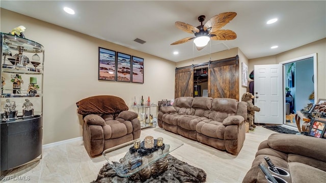 living area featuring a ceiling fan, a barn door, baseboards, visible vents, and recessed lighting