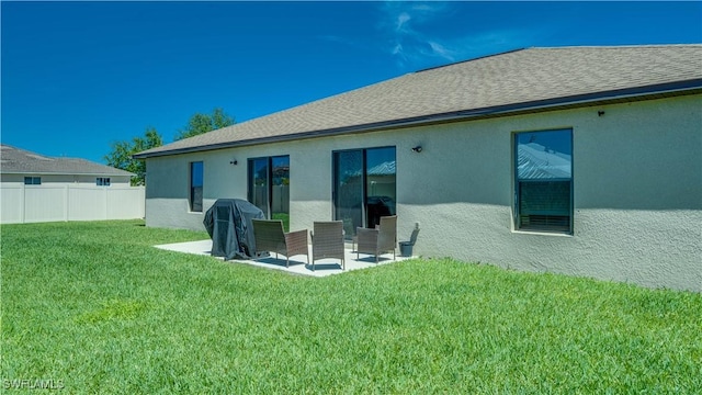 back of property featuring a lawn, stucco siding, fence, and a patio