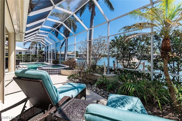 view of patio / terrace featuring glass enclosure and a pool with connected hot tub