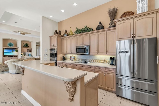 kitchen featuring light tile patterned flooring, open floor plan, appliances with stainless steel finishes, and light countertops