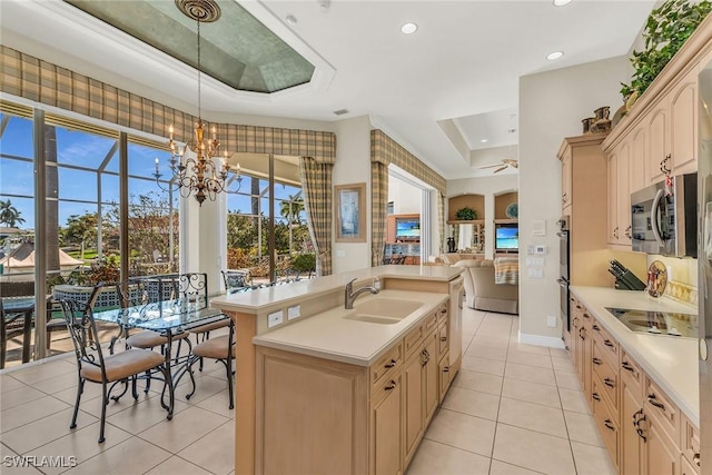 kitchen with a sink, stainless steel appliances, open floor plan, and light countertops
