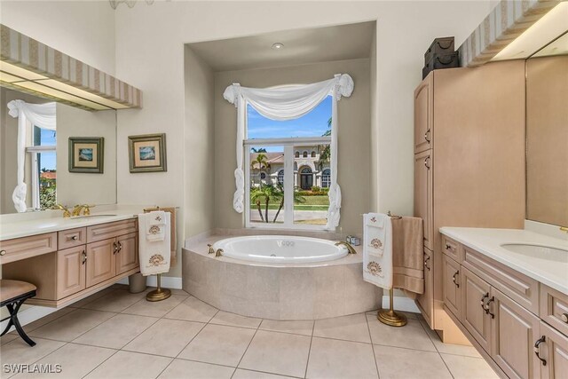 bathroom with tile patterned flooring, a bath, two vanities, and a sink
