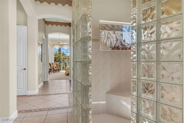 full bathroom featuring tile patterned flooring, a walk in shower, and baseboards