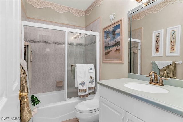 bathroom with combined bath / shower with glass door, toilet, and vanity