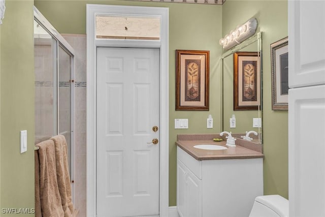 full bathroom with vanity, toilet, and a shower stall