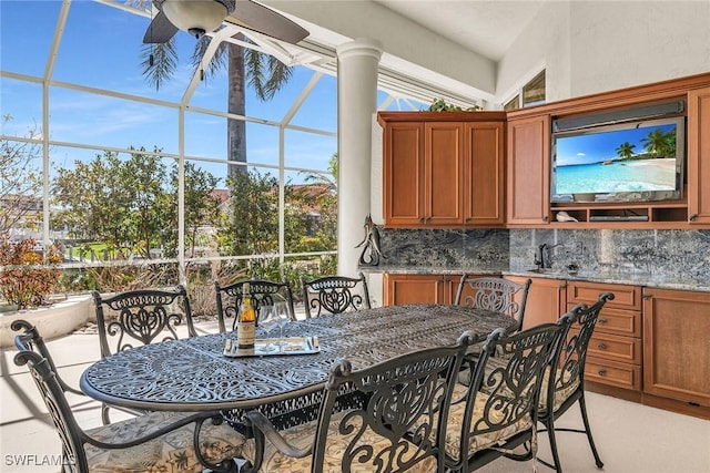exterior space featuring a sink, a lanai, outdoor dining area, and ceiling fan