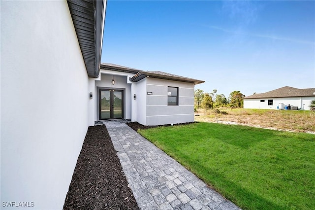 exterior space with a lawn and stucco siding