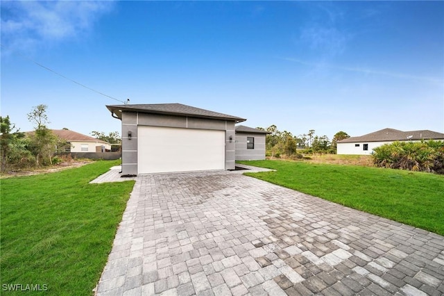 view of front of home featuring stucco siding, a front lawn, an attached garage, and driveway