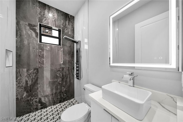 bathroom featuring vanity, toilet, and a marble finish shower