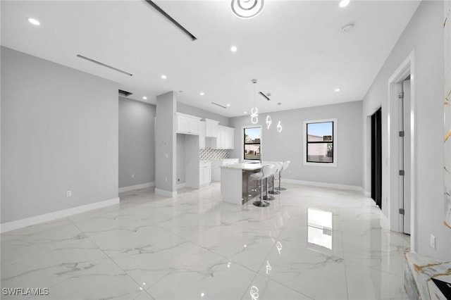 unfurnished living room with recessed lighting, marble finish floor, and baseboards